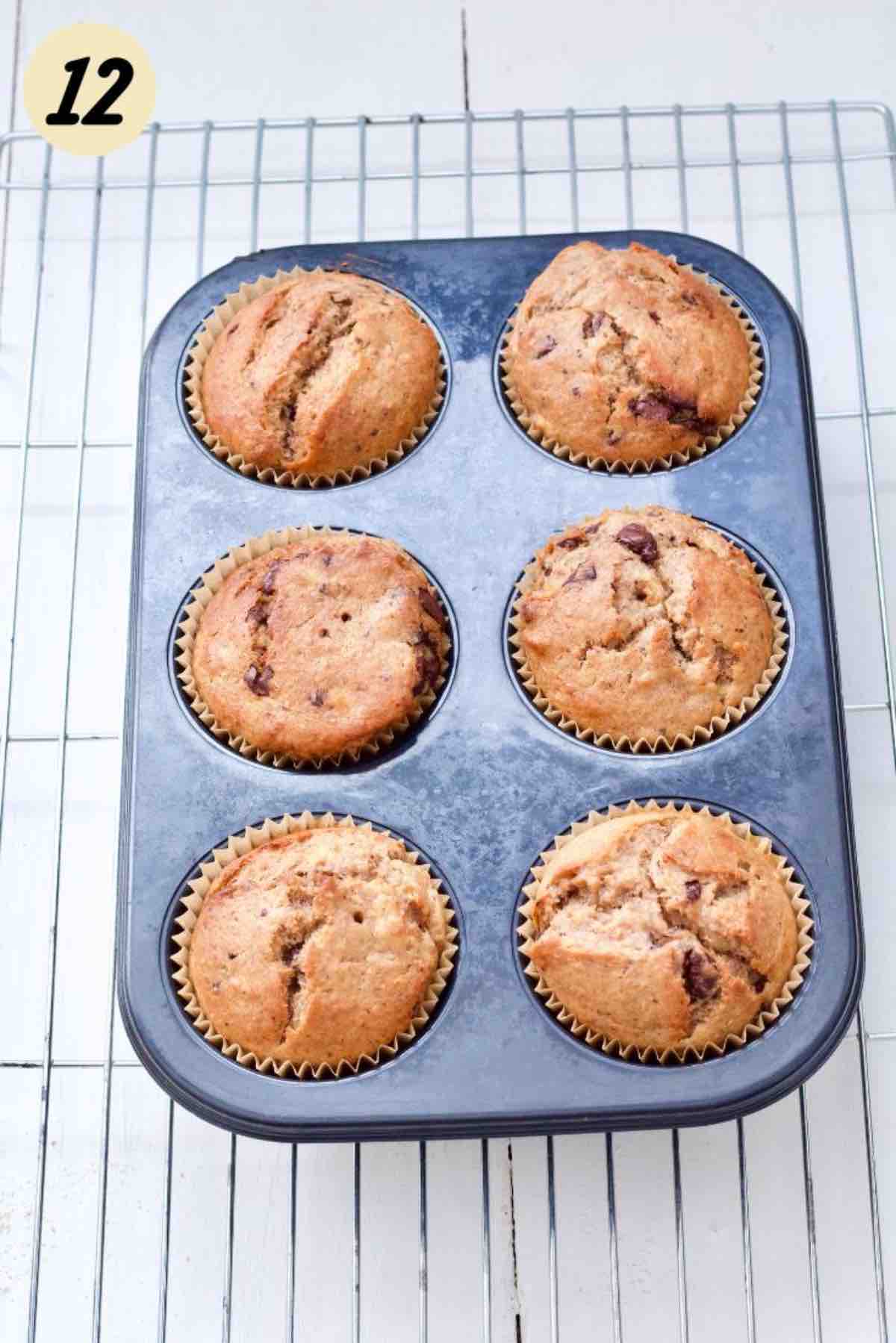 Baked banana muffins in a tin on a cooling rack.