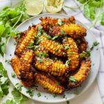 Plate with corn ribs garnished with fresh coriander.