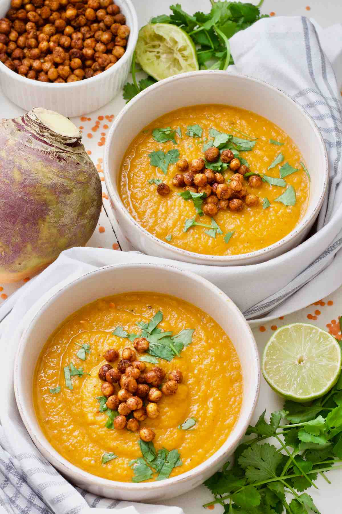 Two bowls of soup with garnishes.