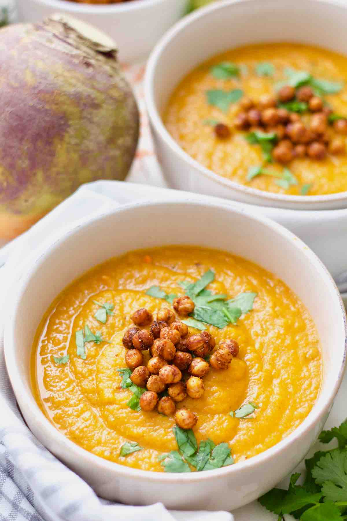 Bowl of carrot and swede soup with another in the background.