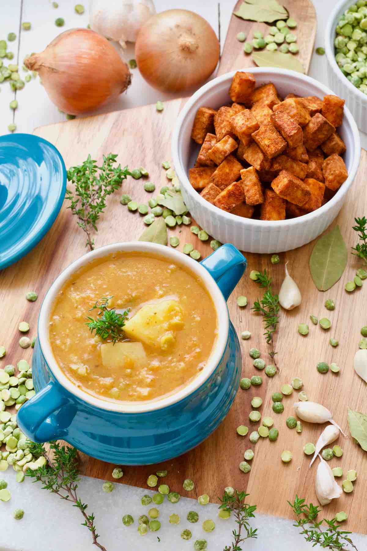 Bowl with soup with visible potatoes sticking out & fresh thyme.