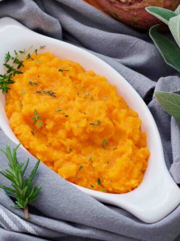 Close up of carrot and swede mash in a dish.