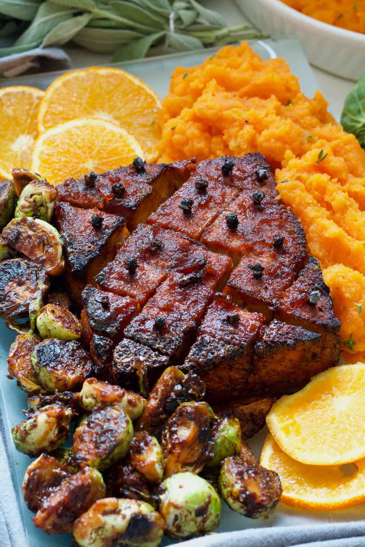 Platter with tofu roast, sides and orange slices.