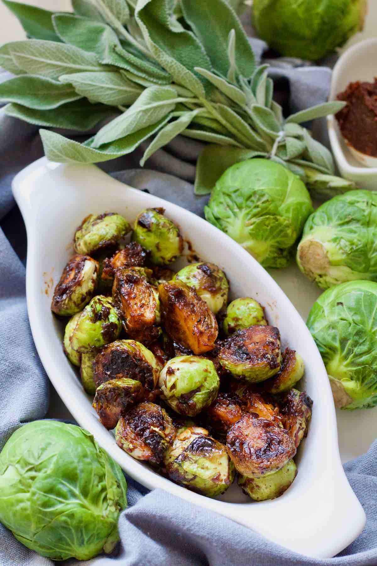 Asian Brussels sprouts surrounded by raw sprouts and herbs.