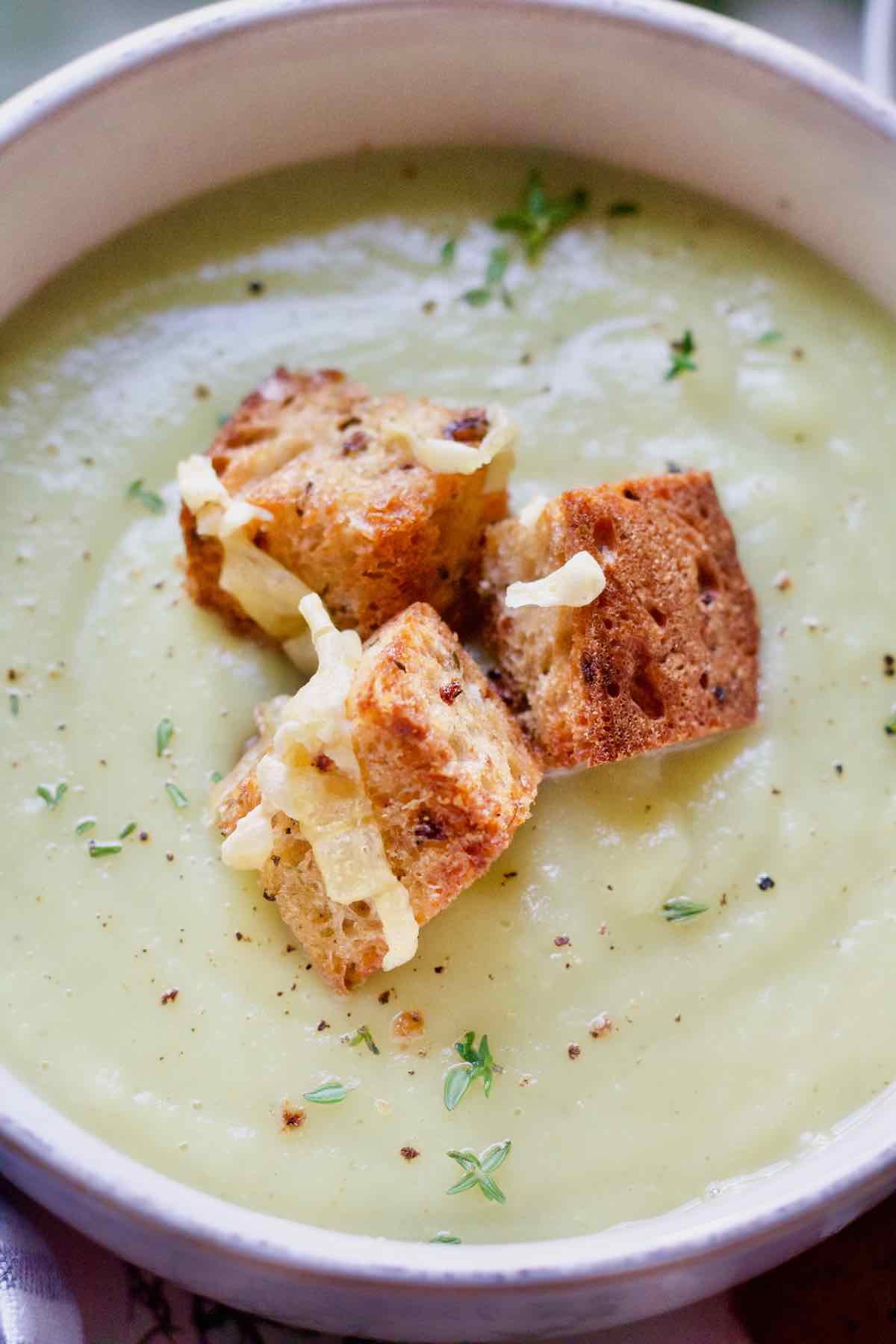 Close up of broccoli stalk soup and croutons.
