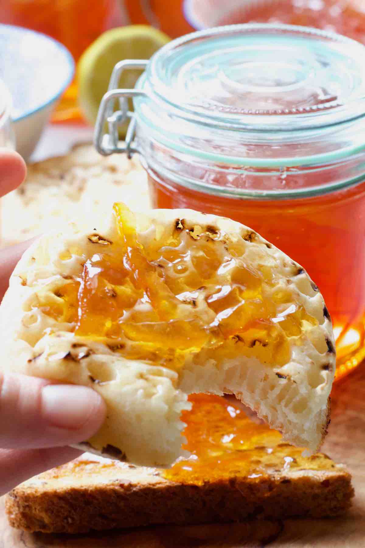 Crumpet with marmalade with bite taken out of it.