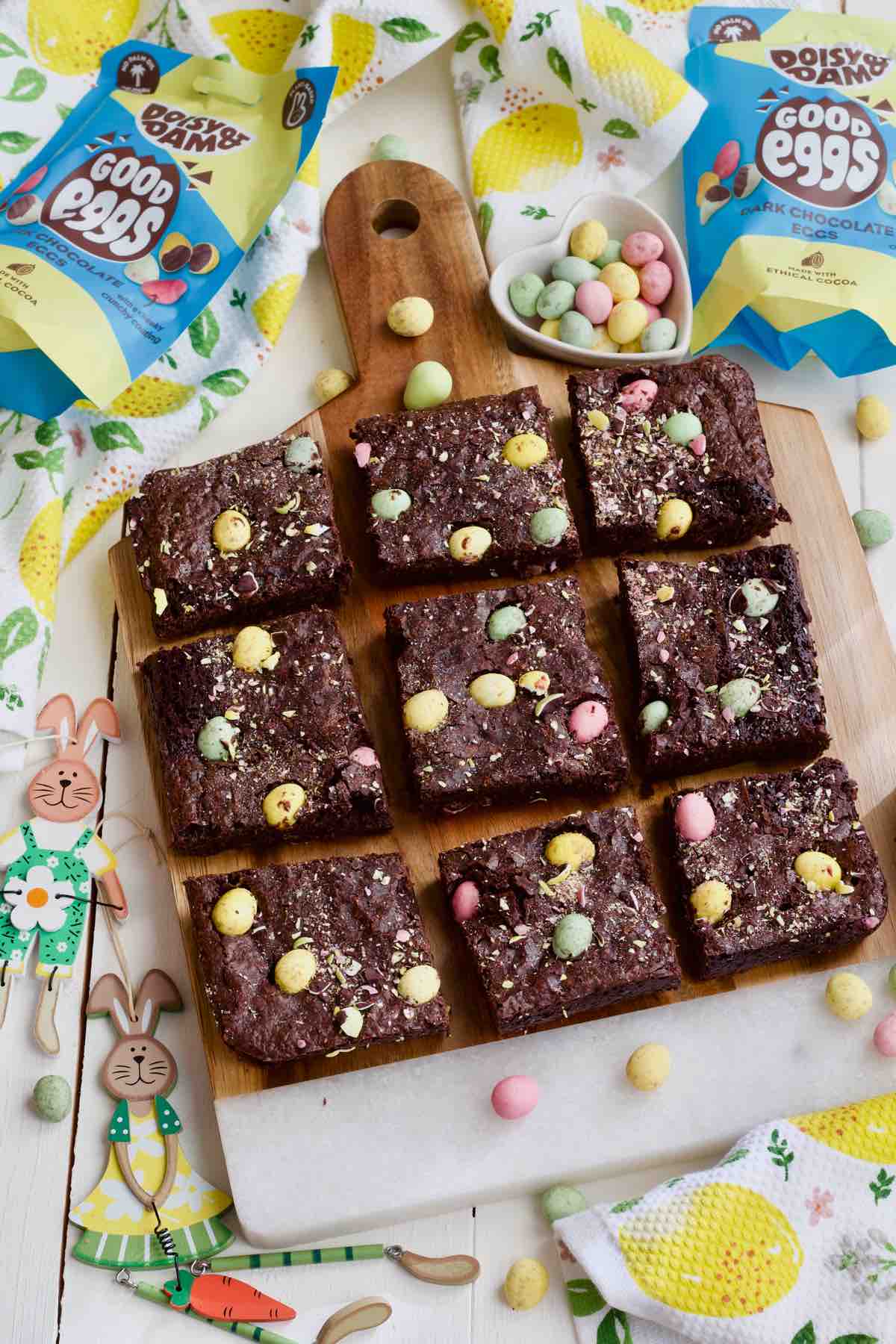 Mini egg brownies cut into 9 squares on a board.