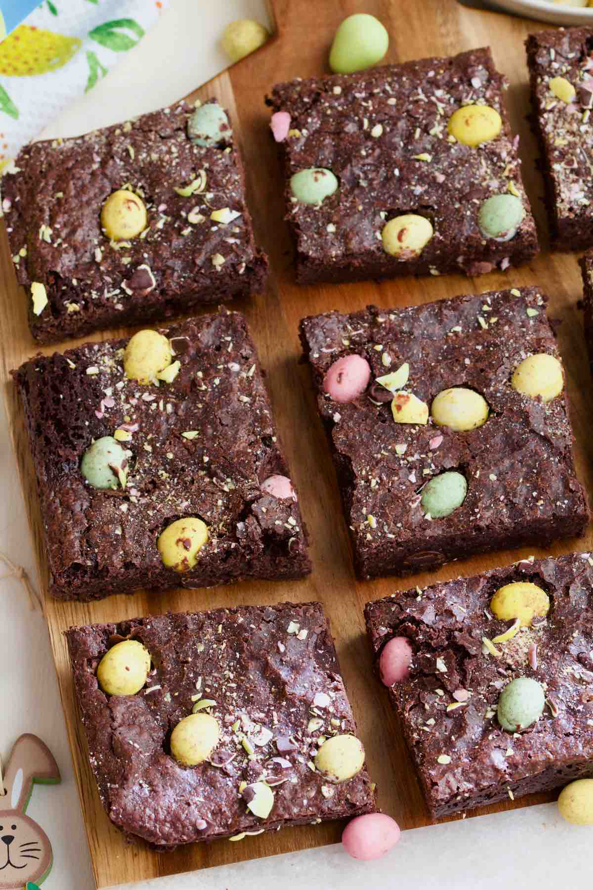 Mini egg brownie squares on a board.