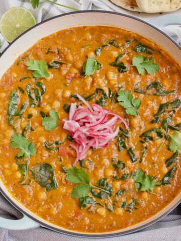 Pan with garnished chickpea and spinach curry.