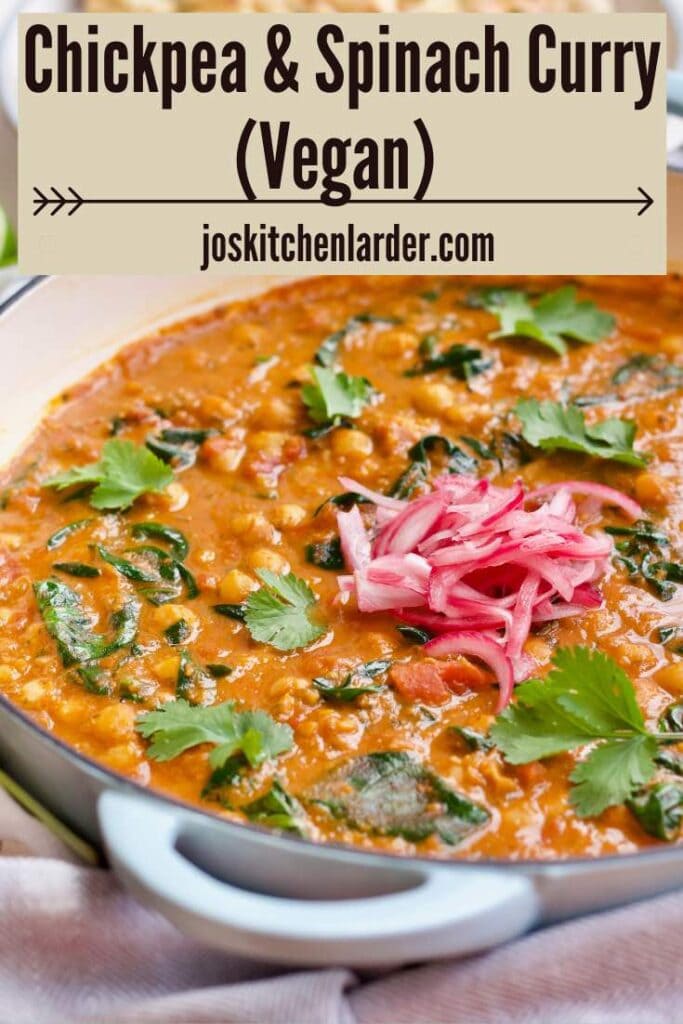 Pan with finished and garnished chickpea and spinach curry.