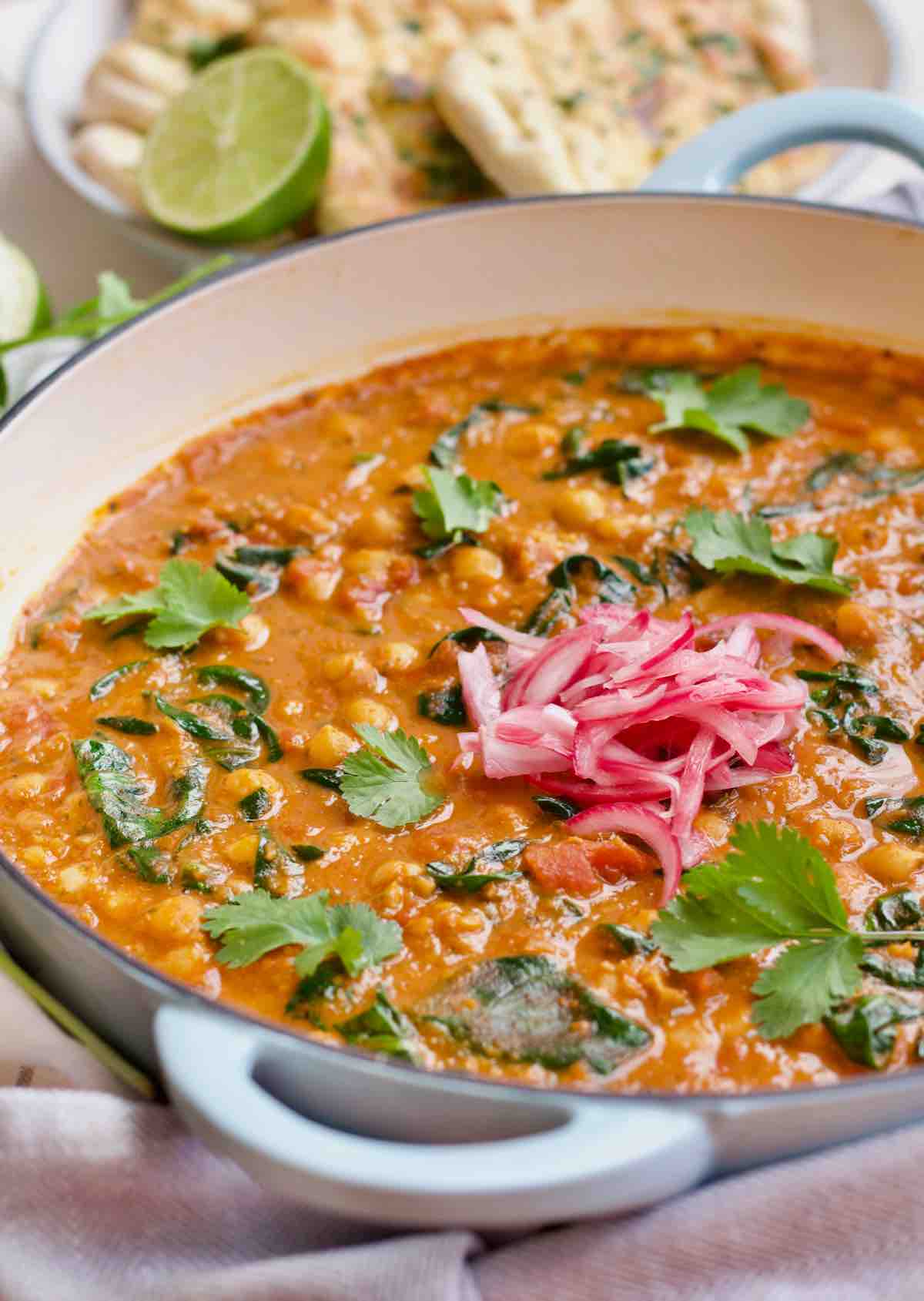 Pan with finished and garnished chickpea and spinach curry.