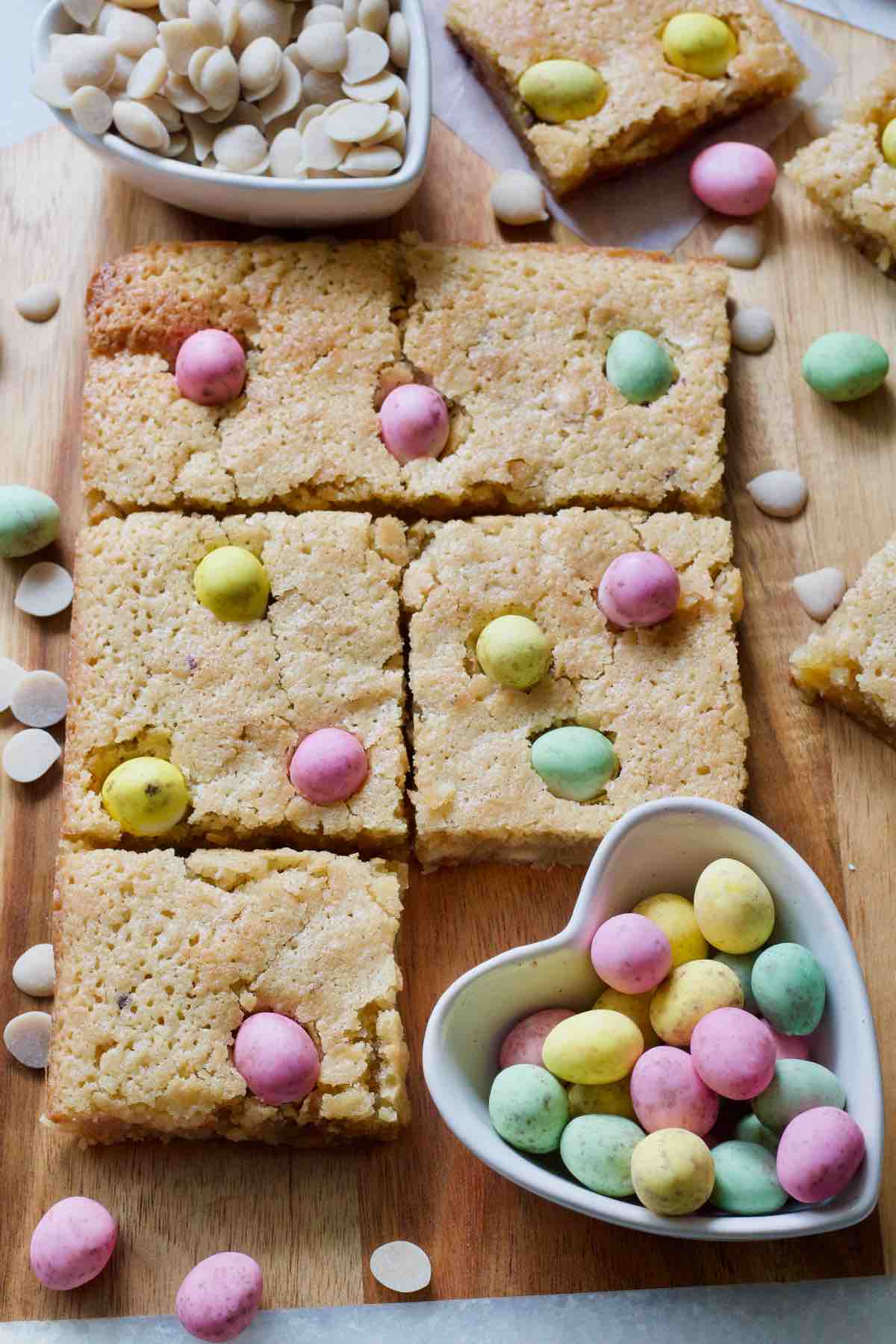 Mini egg blondies and with mini eggs in a heart shaped bowl.