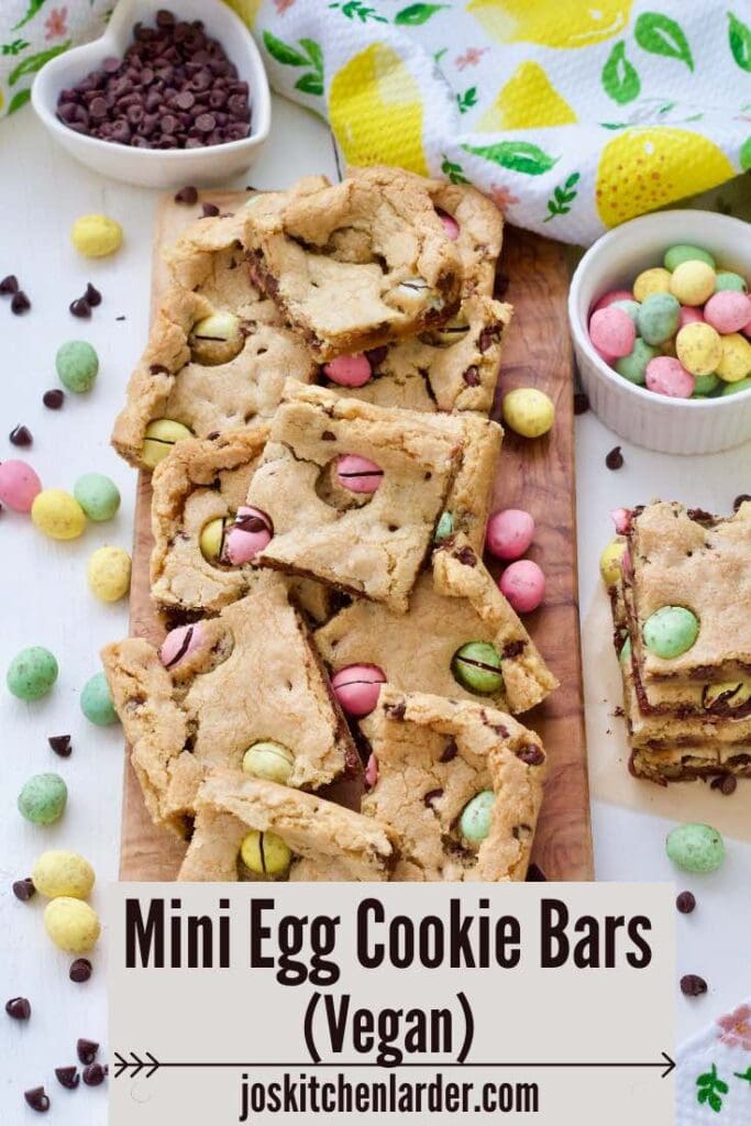 Cookie bars on a board with extra mini eggs and chocolate chips.