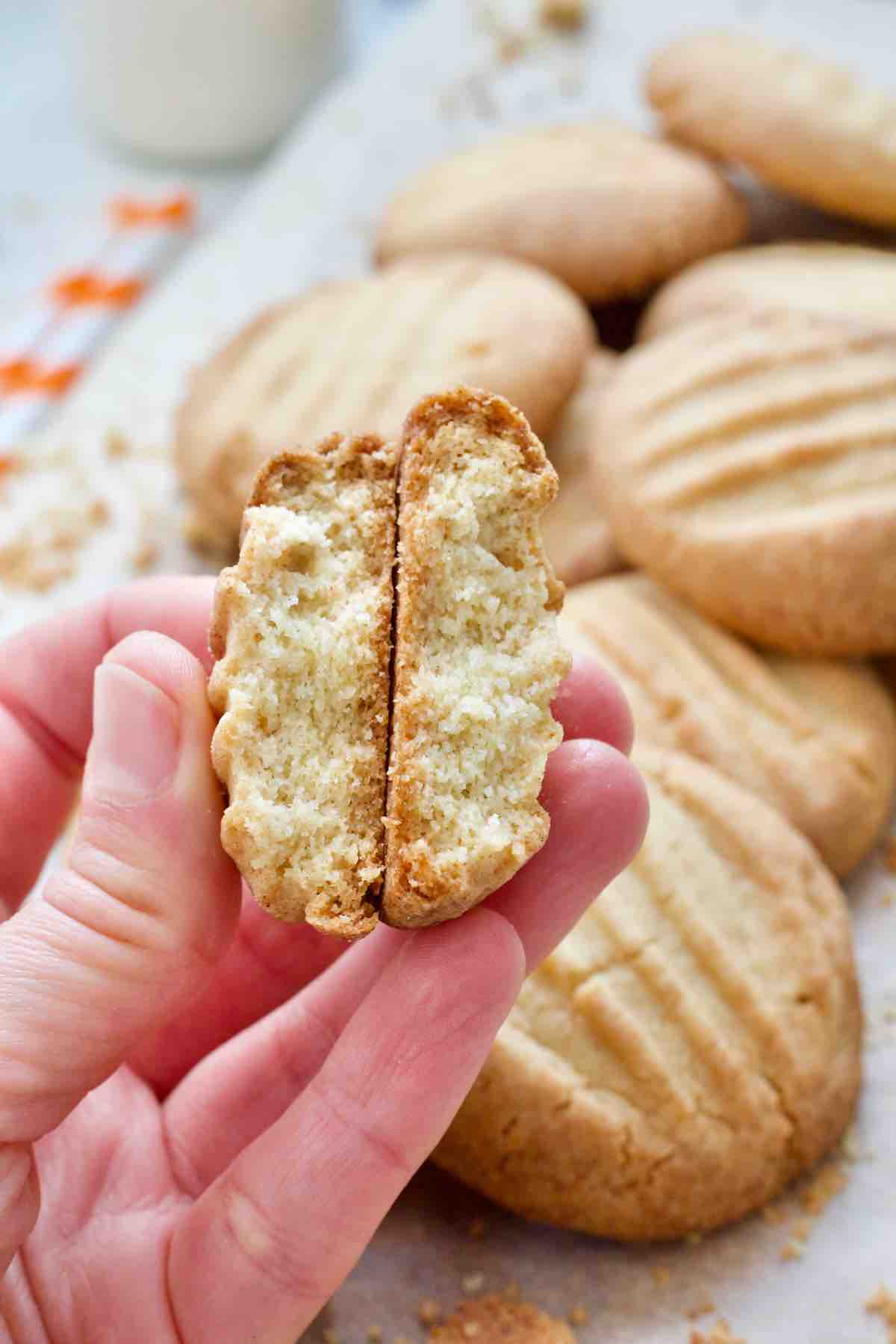 Hand holding a biscuit split in half.