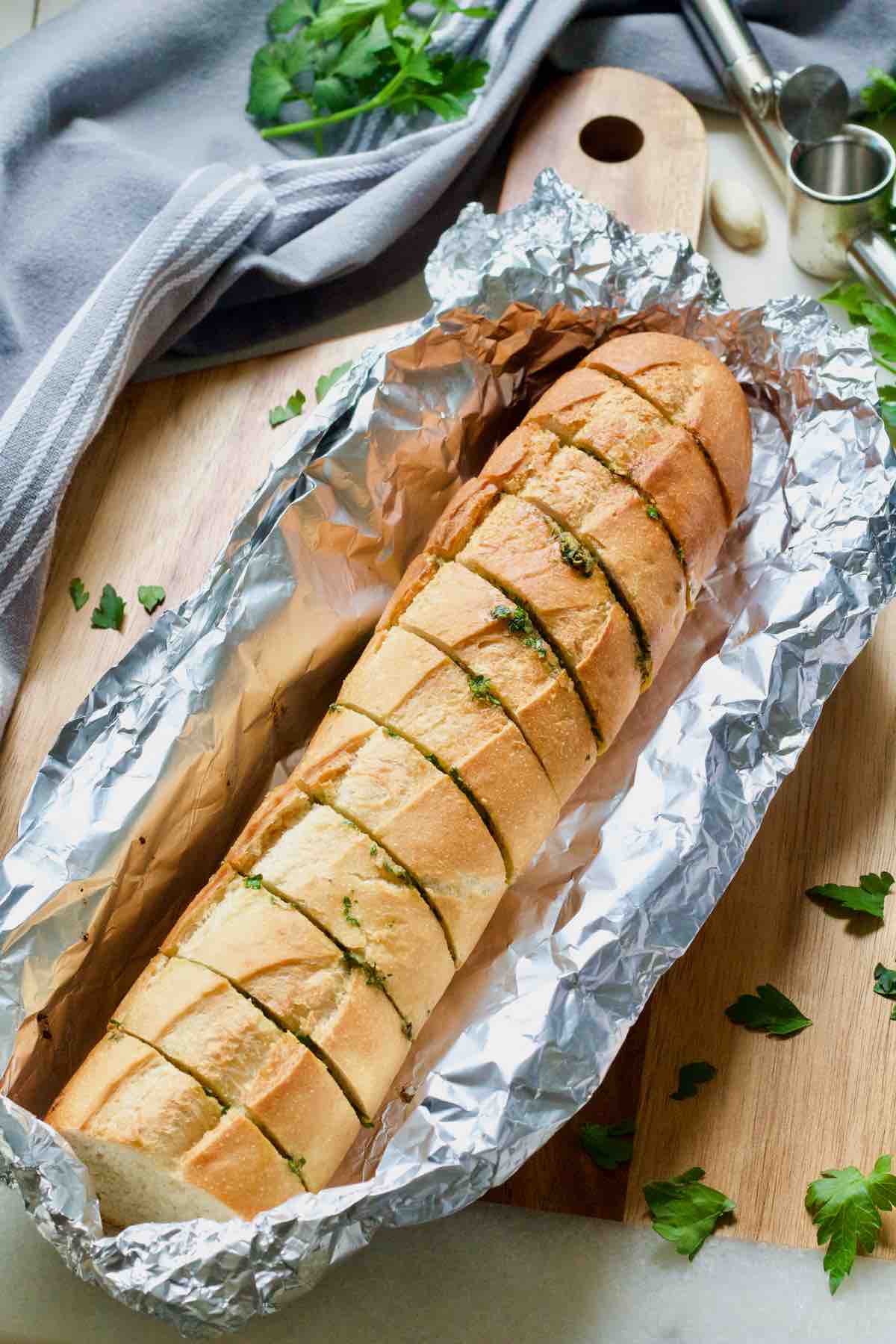 Baked vegan garlic bread resting in a foil parcel.