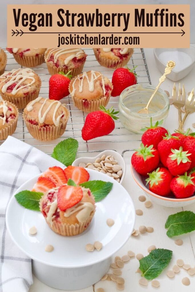 Decorated vegan strawberry muffin on a plate with more muffins in the background.