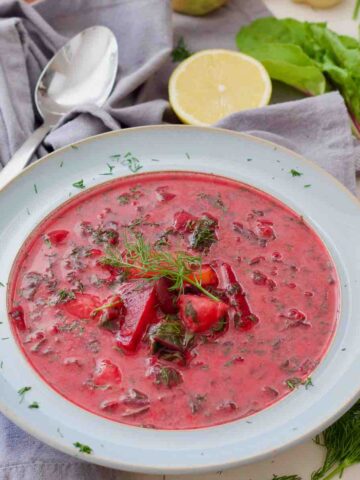 Beet greens soup, spoon, lemon and leafy greens.