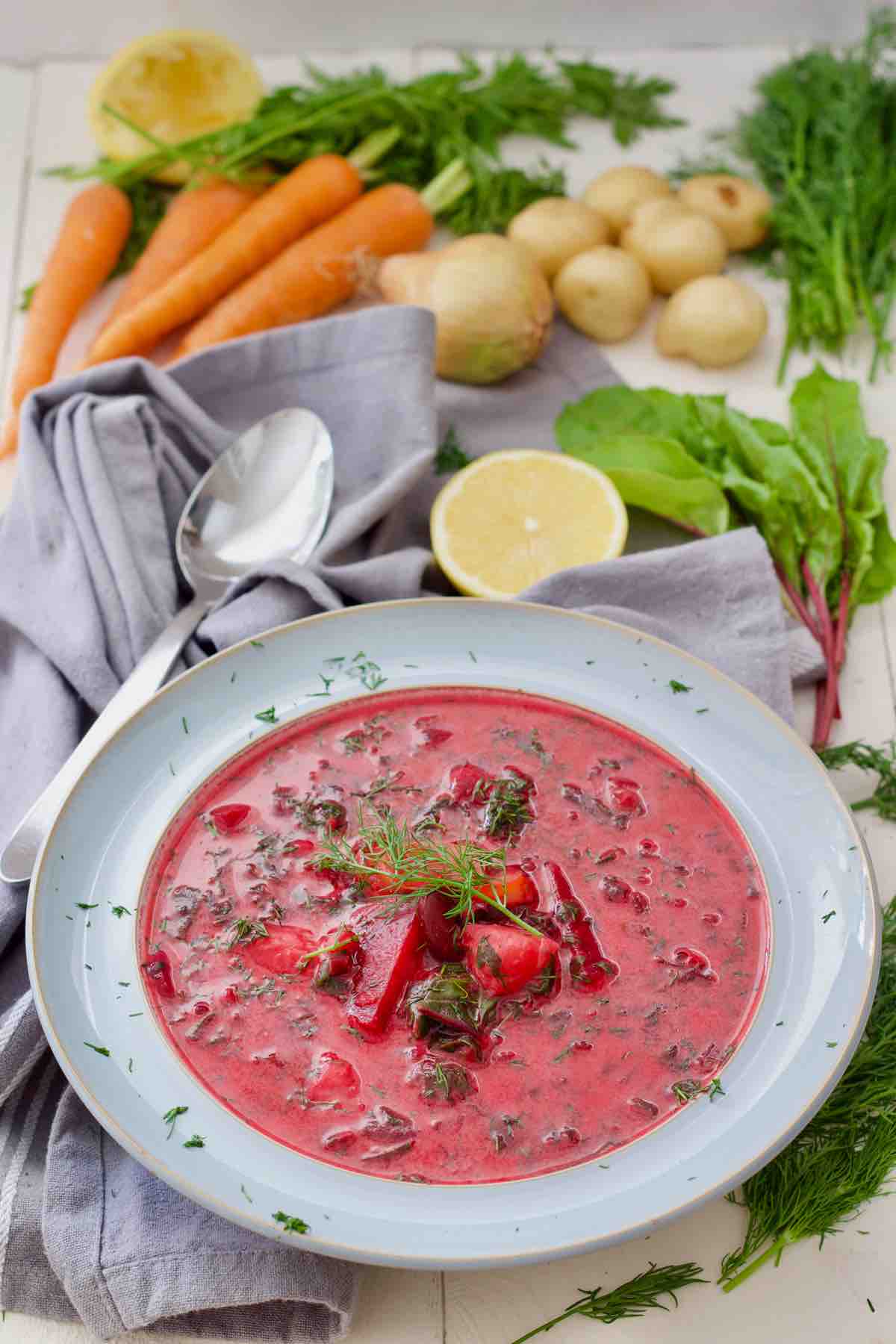 Bird view of plate with beet greens soup and fresh veg around it.