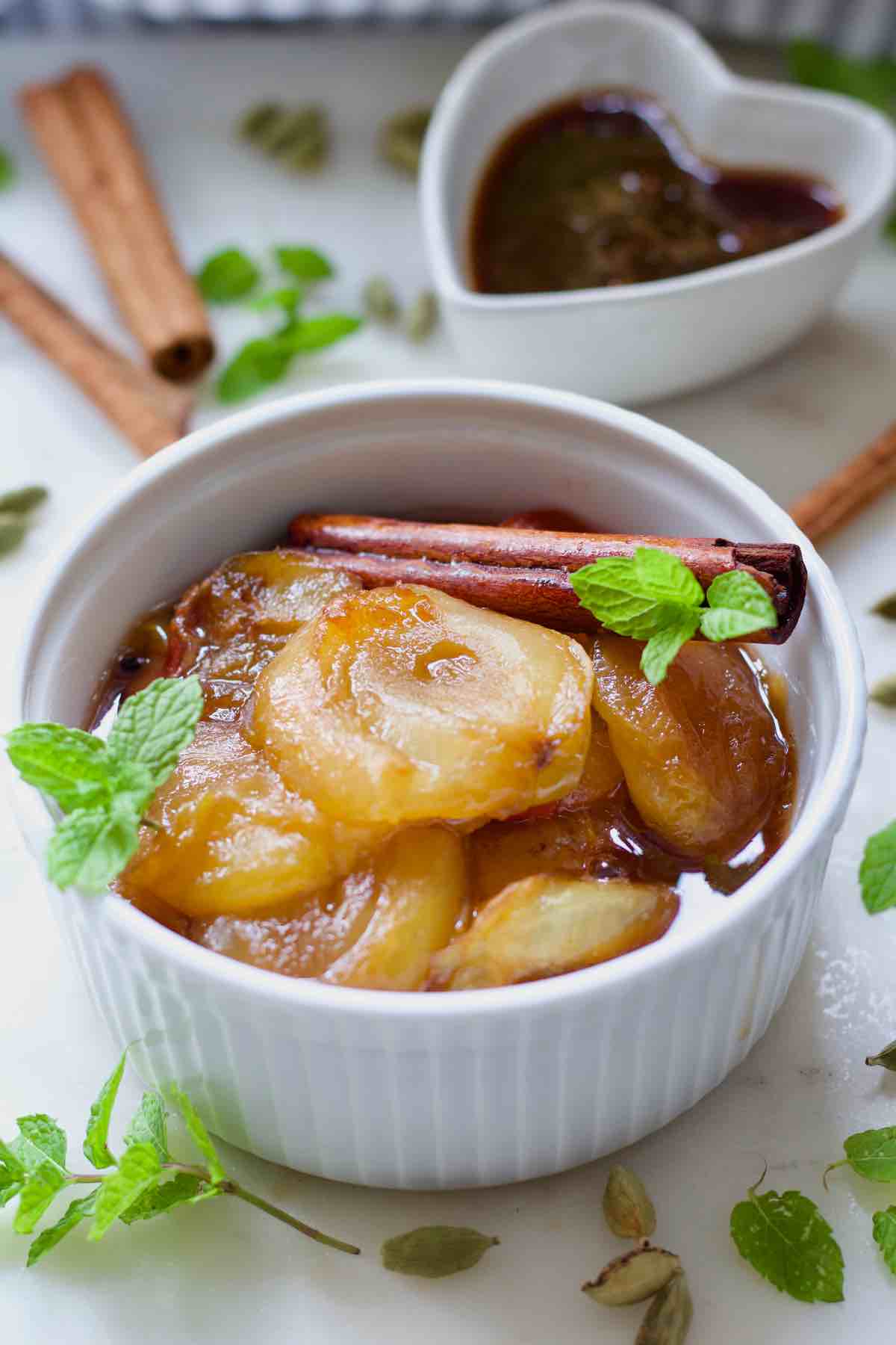Bowl with stewed plums decorated with fresh mint.