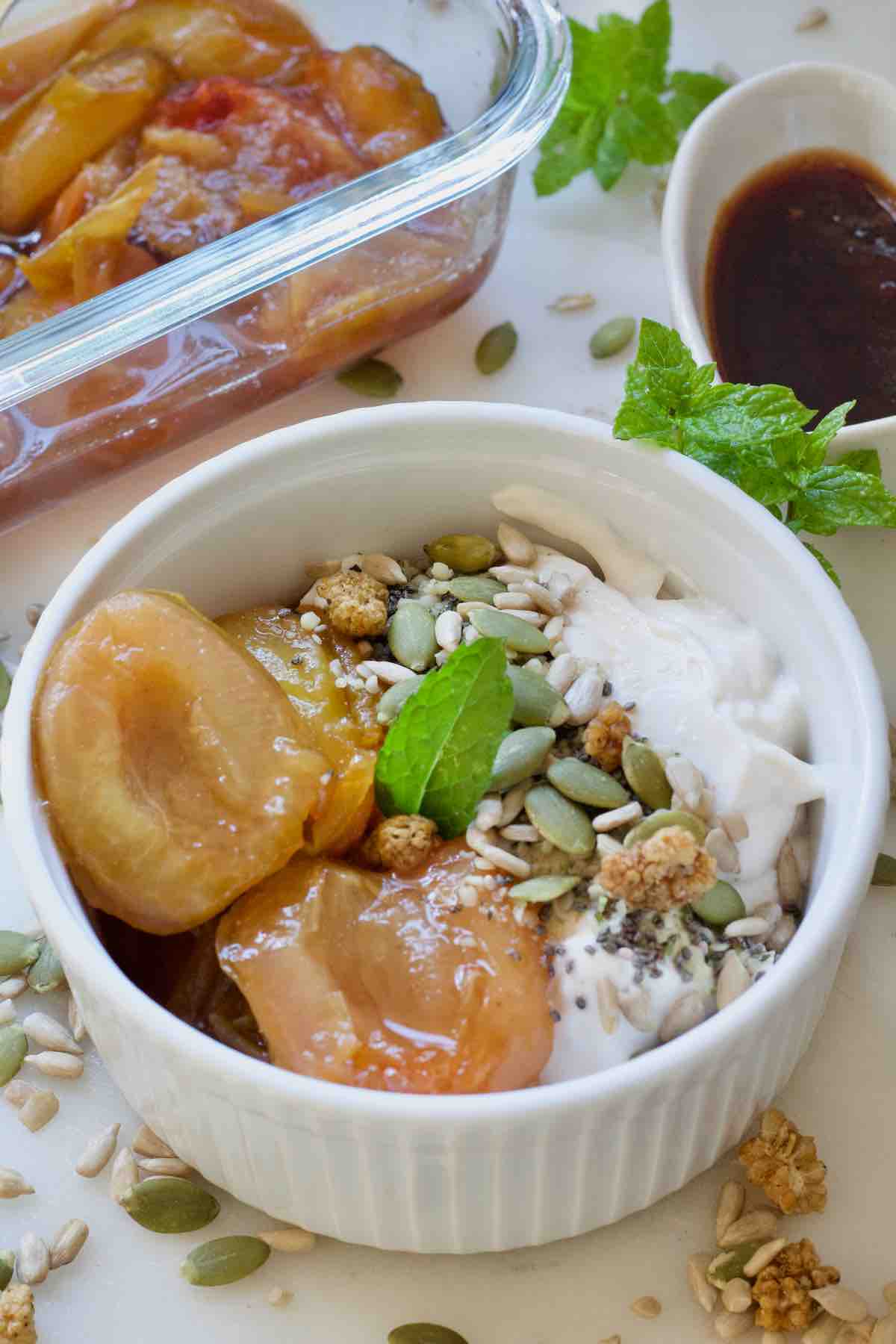 Stewed plums served with yogurt and seeds.