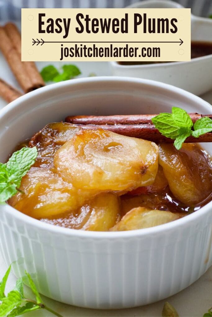 Close up of stewed plums in a bowl with cinnamon stick and mint.