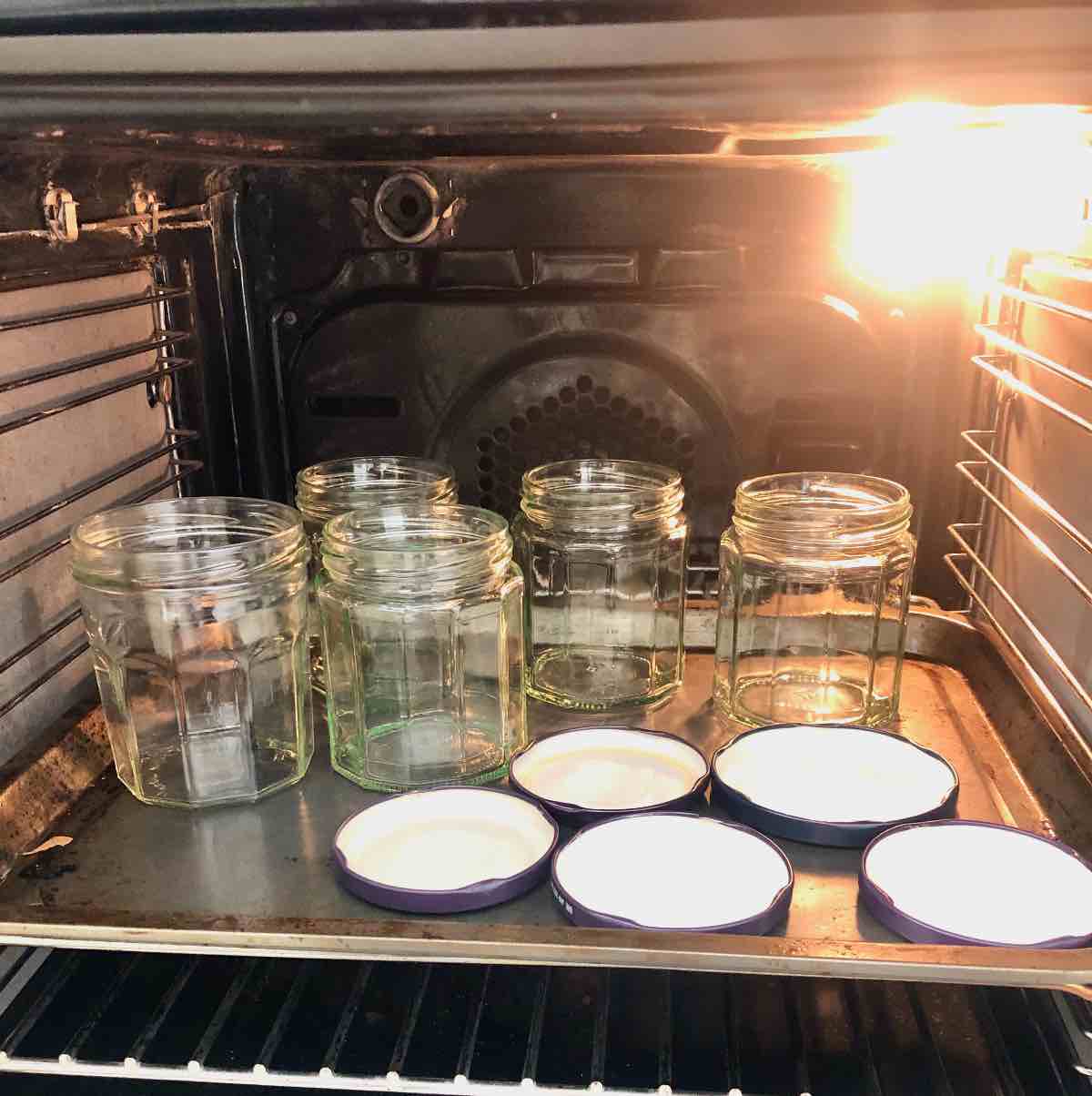 Jars and lids shown sterilising in the oven.