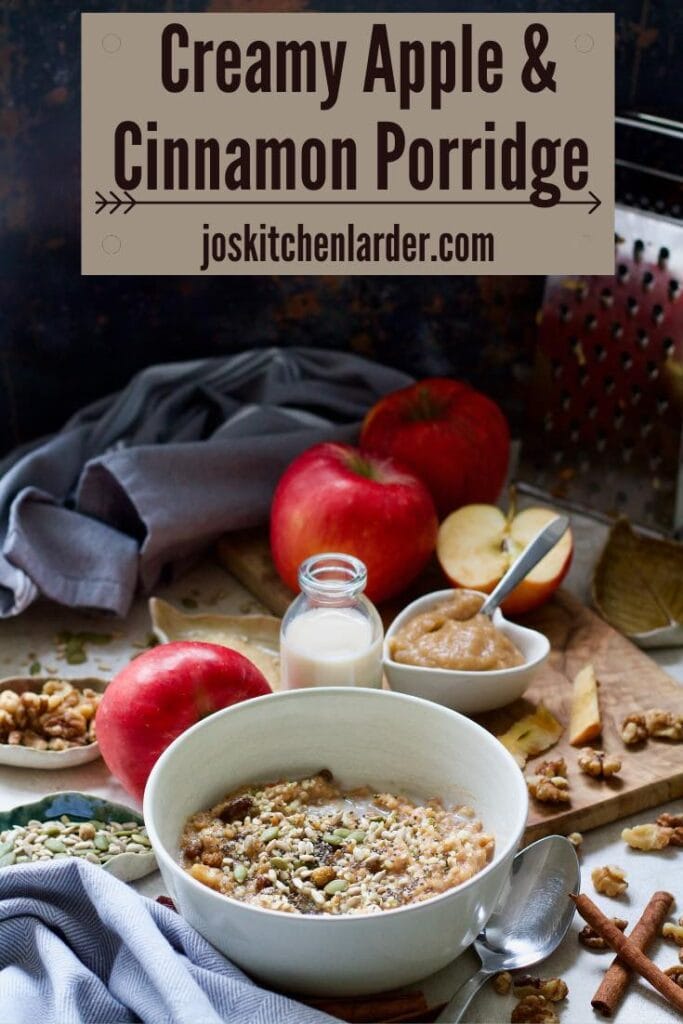 Breakfast setup with bowl of porridge, apples, plant milk, nuts, seeds and spices.