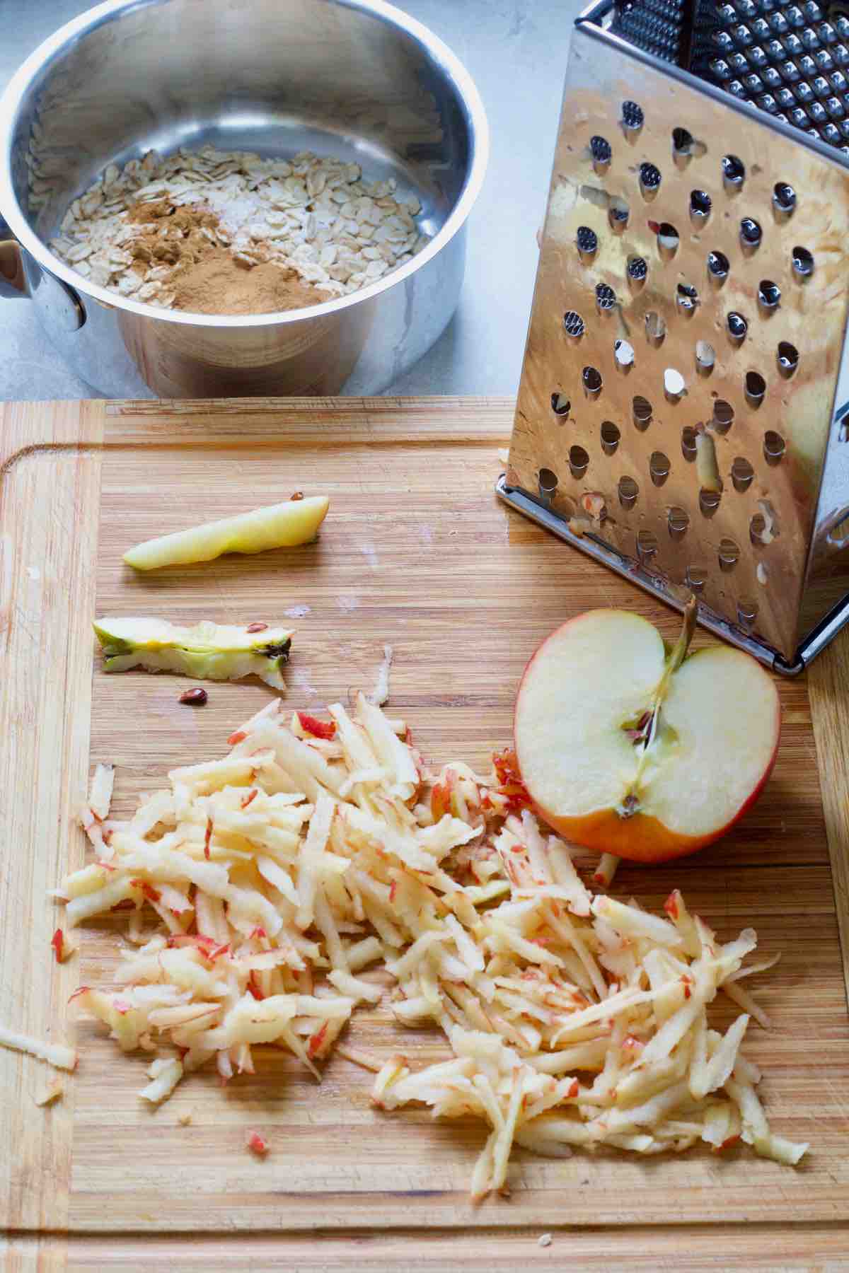 Grated apple on a board with box grater.