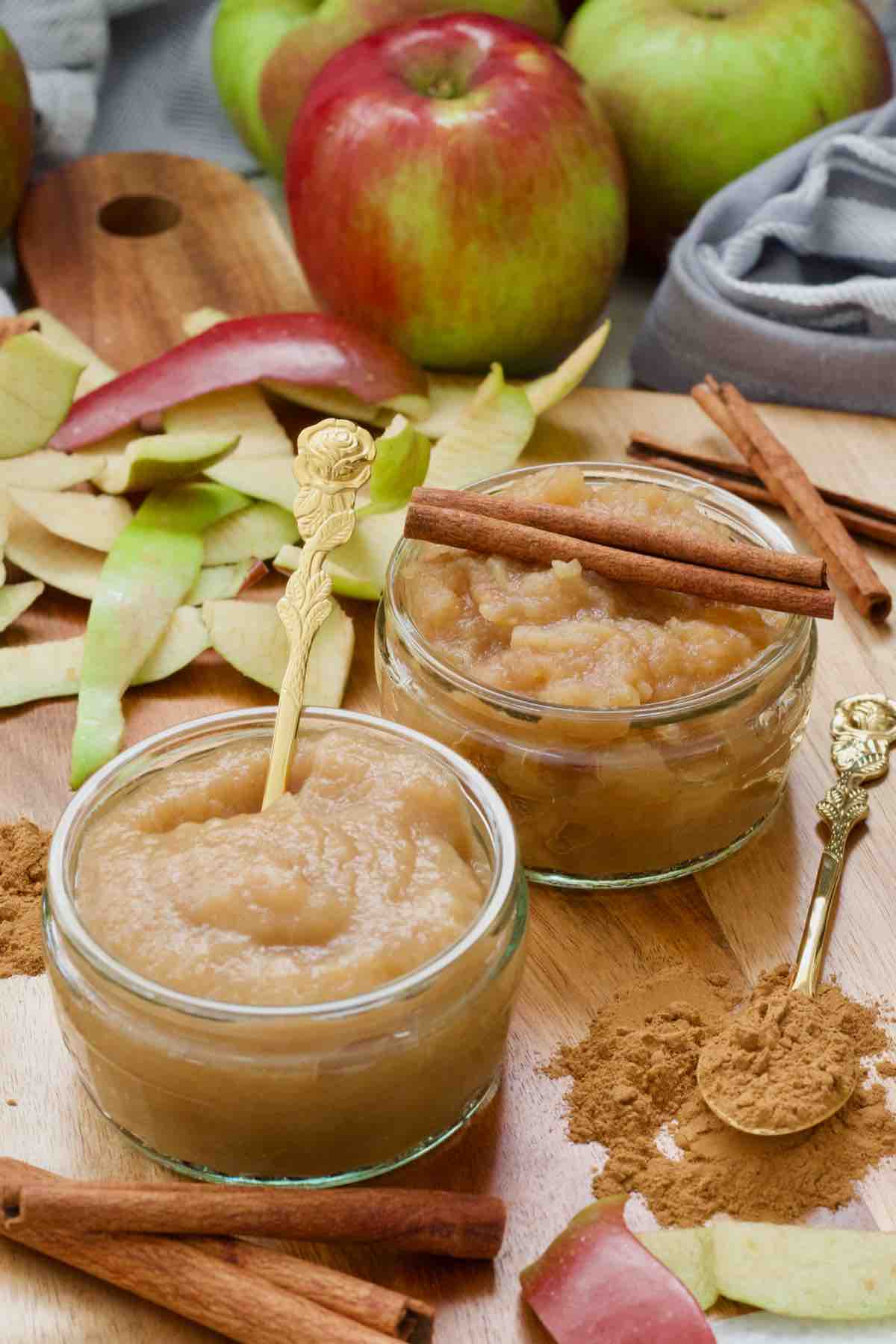 Two bowls with apple puree - smooth and chunky, apple peels and cinnamon.