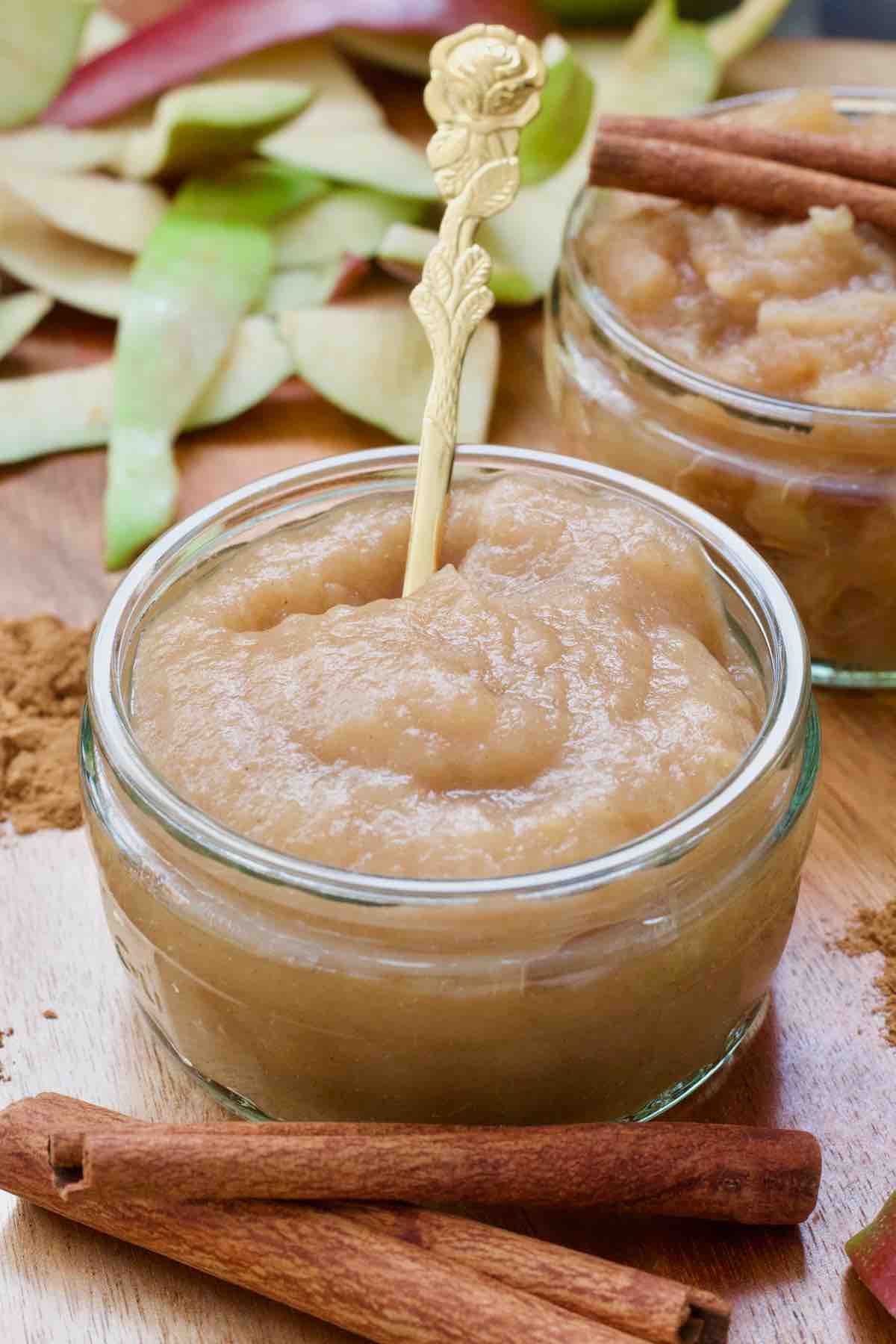 Smooth apple puree in a small dish with a spoon.