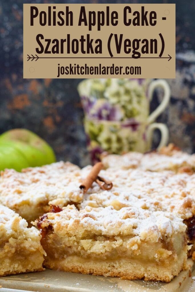 Close up of cut polish apple cake with two tea cups in the background.