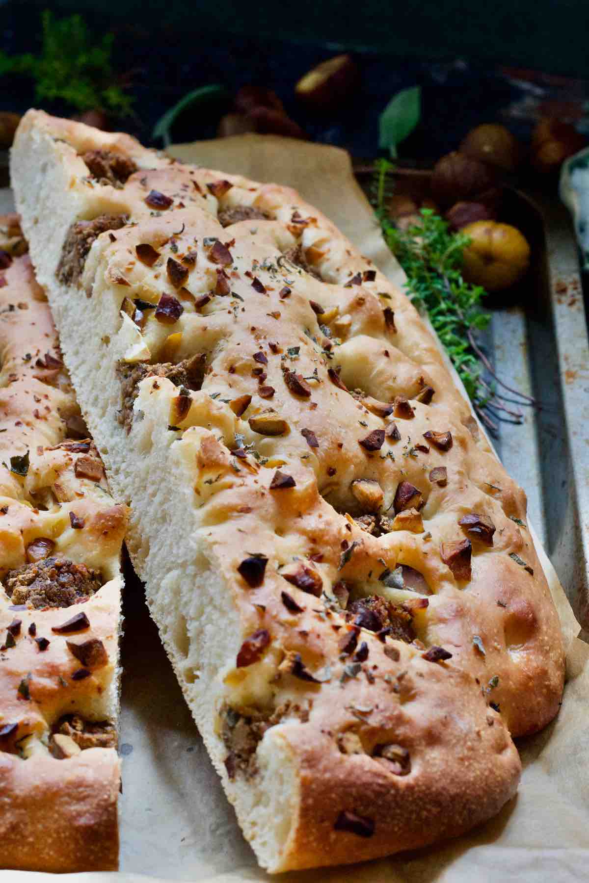 Half of a focaccia slab resting slightly on top of another half.