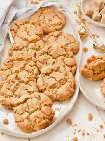 Close up of platter with chewy ginger cookies, crumbs around.