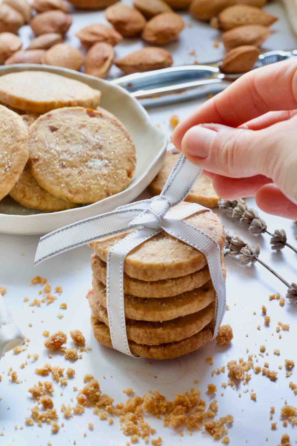 Hand tying a bow on top of shortbread stack.