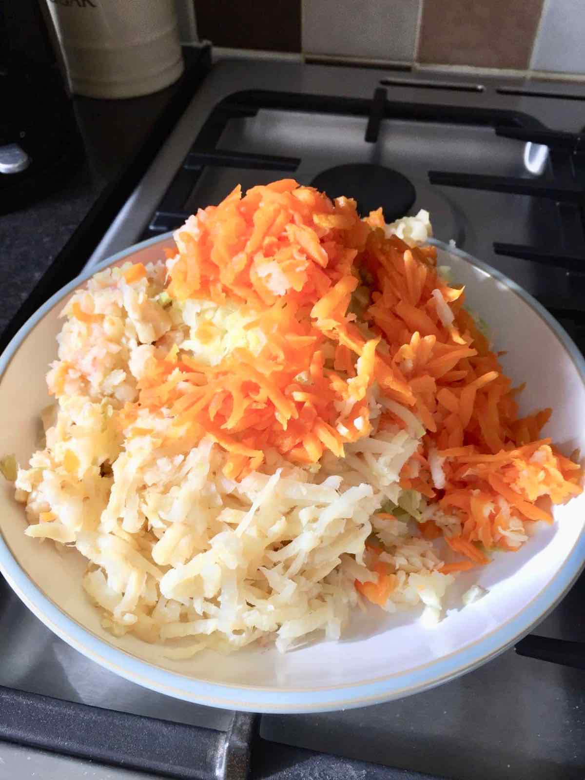 Cooked vegetables coarsely grated on a plate.