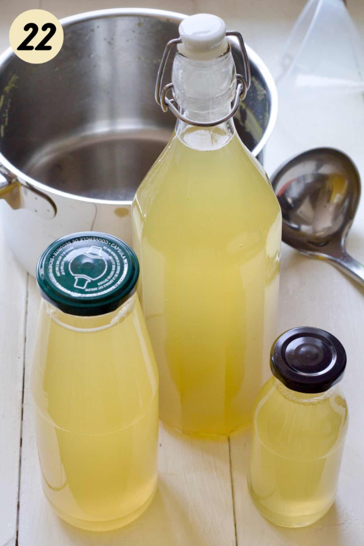 Three bottles filled with elderflower syrup.
