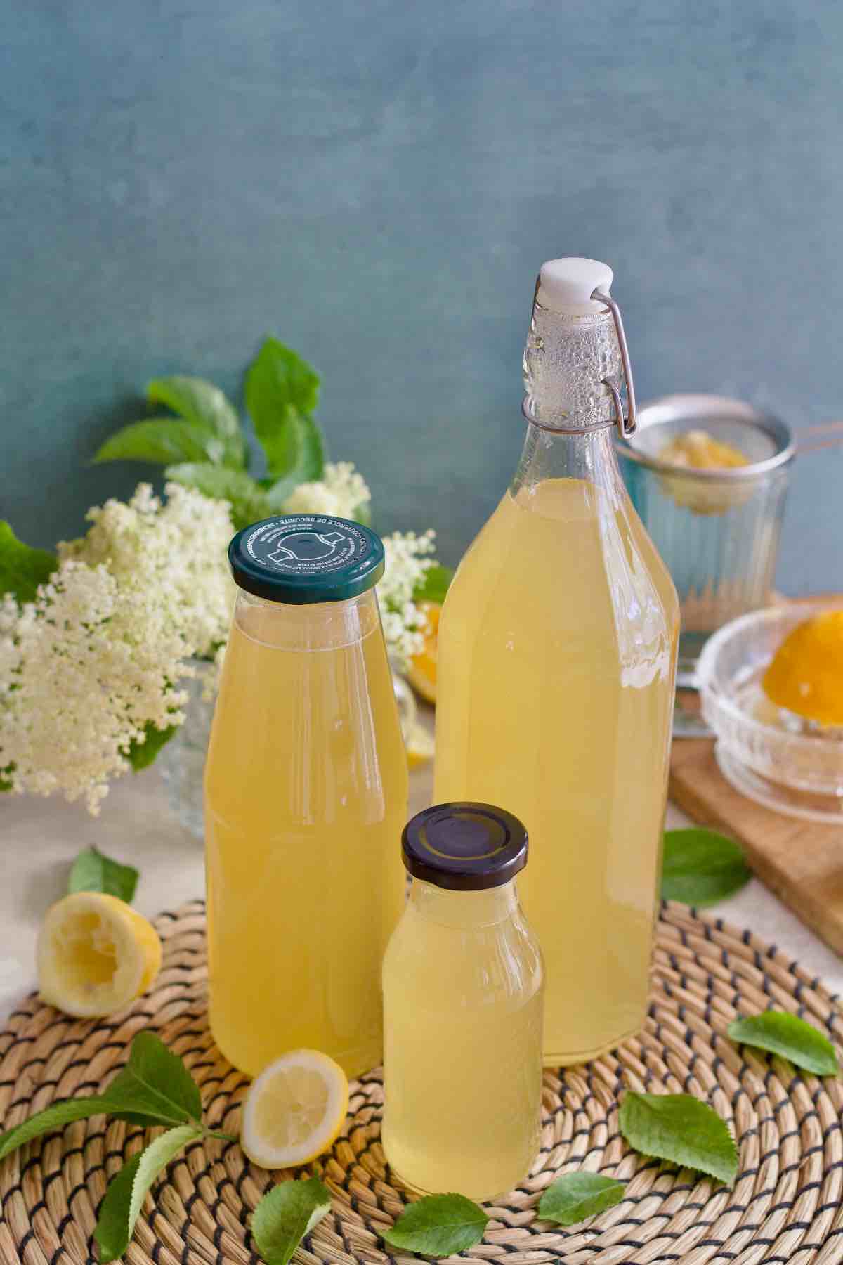 Three bottles of elderflower syrup on a mat.