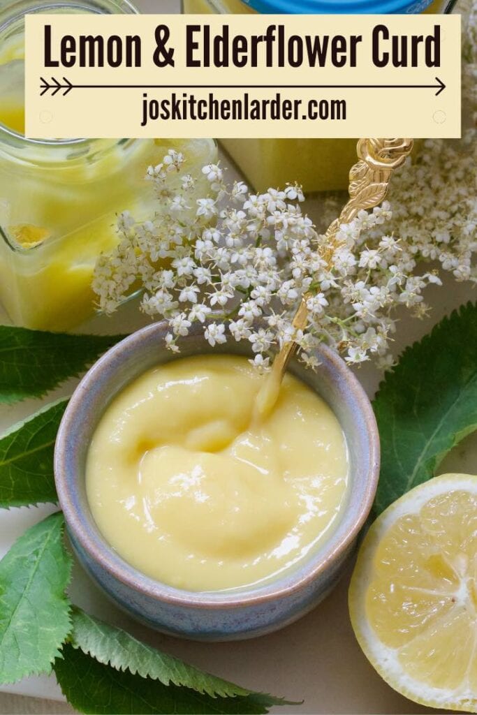 Small bowl with curd, open, jar, half a lemon and elderflowers and their leaves.