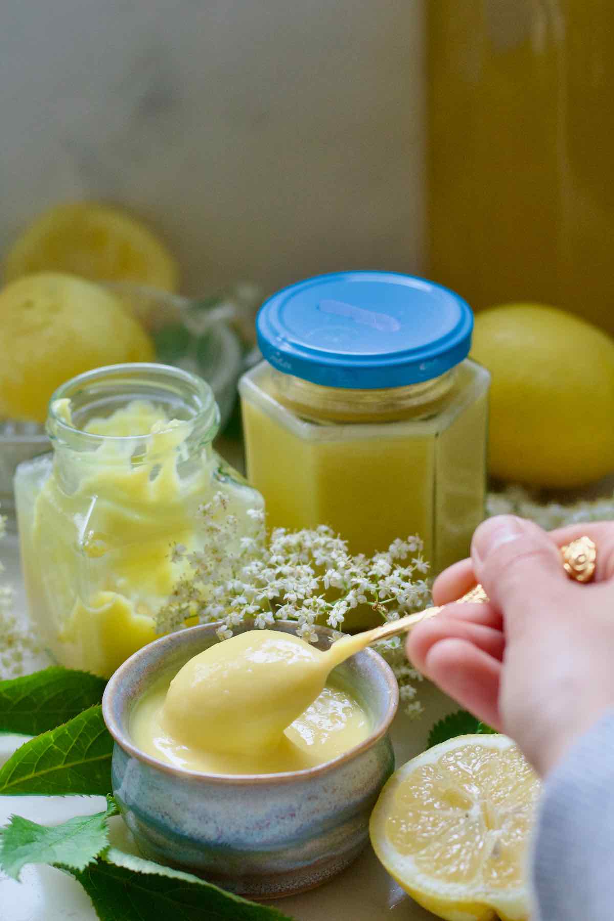 Hand holding a spoon full of elderflower curd.