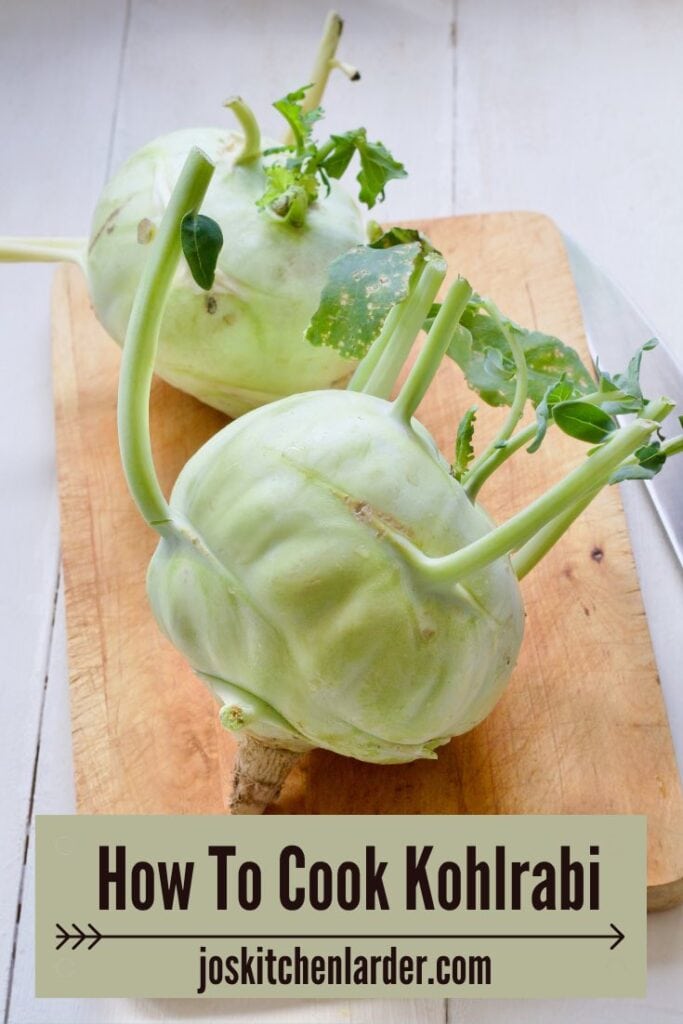 Two kohlrabi bulbs on a wooden board.
