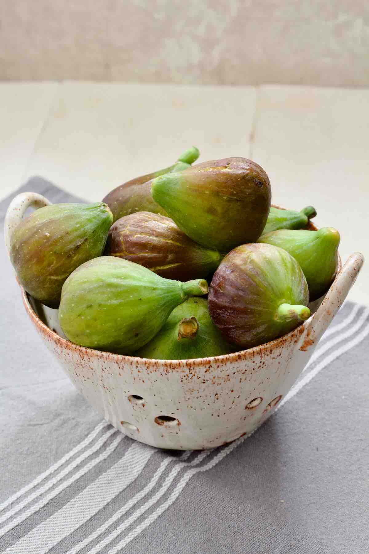Figs in a small ceramic colander.