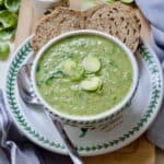 Close up of Brussels sprouts soup in a bowl with two slices of granary bread.