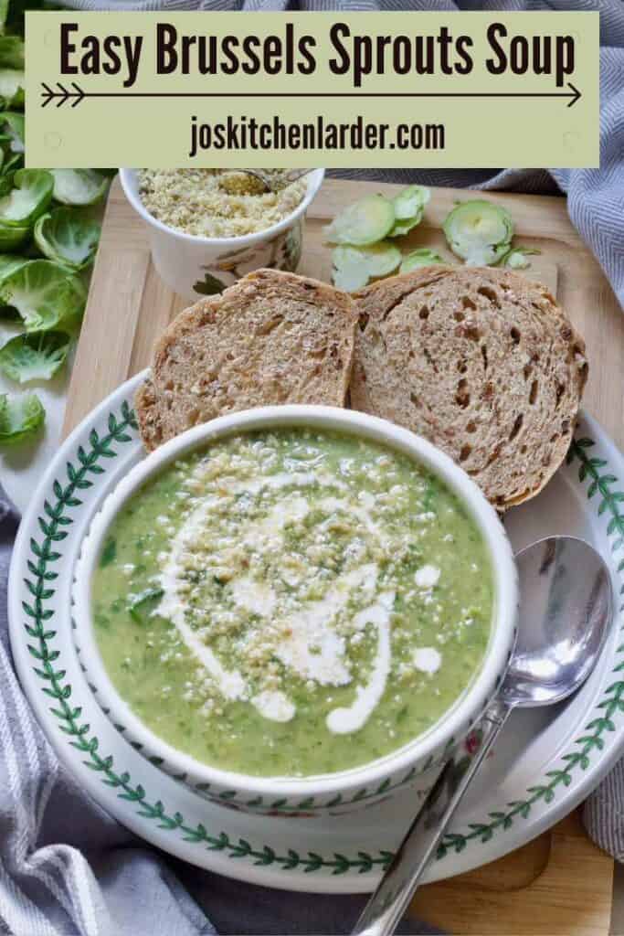 Bowl of Brussels sprouts soup on a plate with a spoon and granary bread slices.