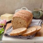 Granary bread with three slices freshly cut in front of it.