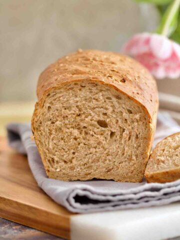 Granary bread on top of kitchen towels with end bit cut off.