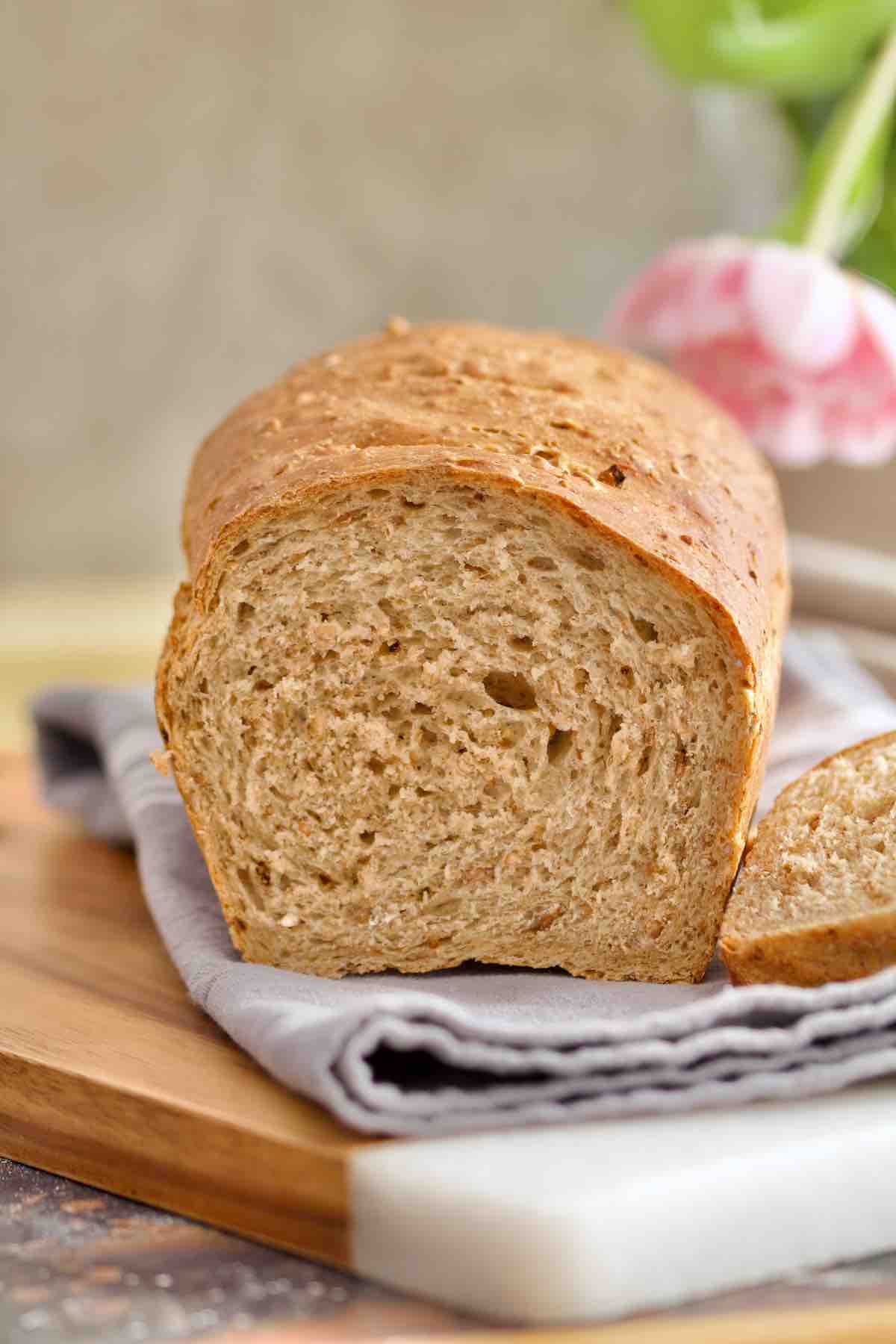 Granary bread on top of kitchen towels with end bit cut off.