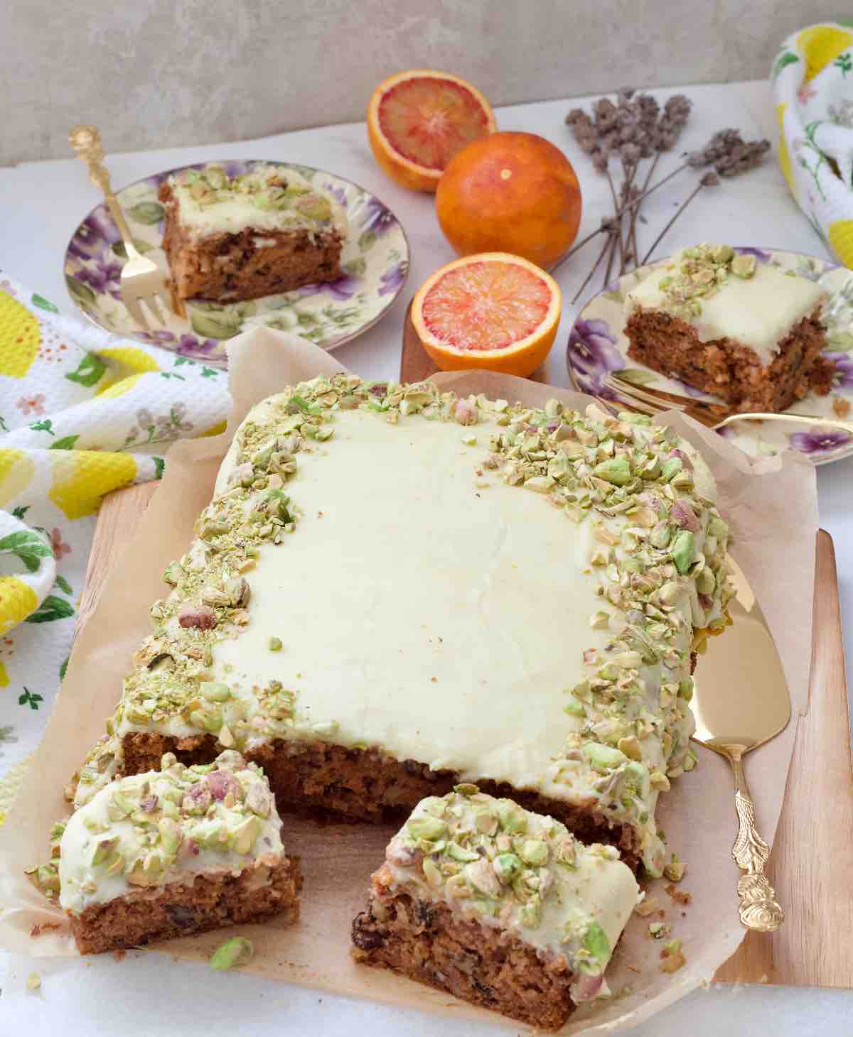 View of carrot cake traybake with plated portions and extra two slices.