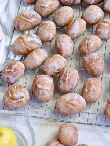 Close up of iced pierniczki spread out on a cooling rack.