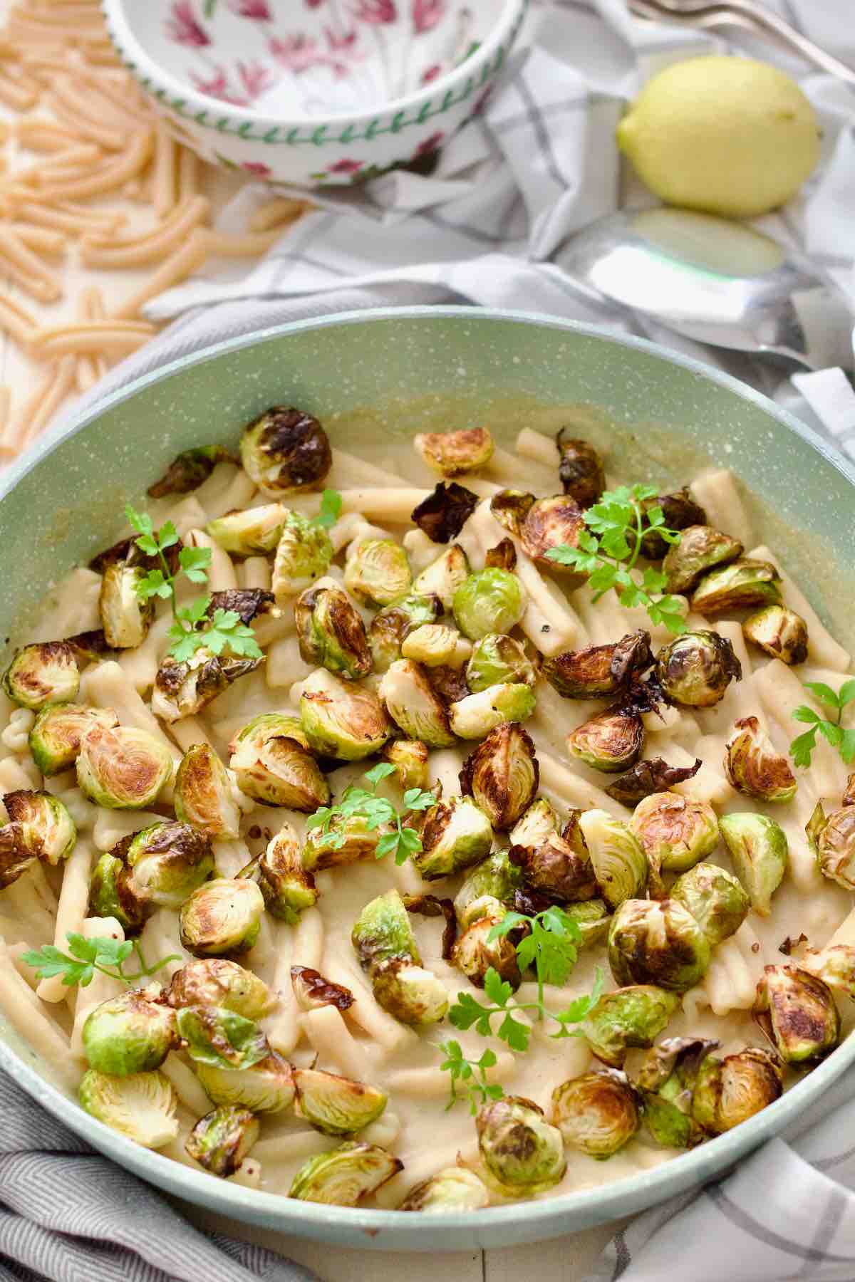 Roasted Brussels sprouts pasta in a pan garnished with fresh parsley leaves.
