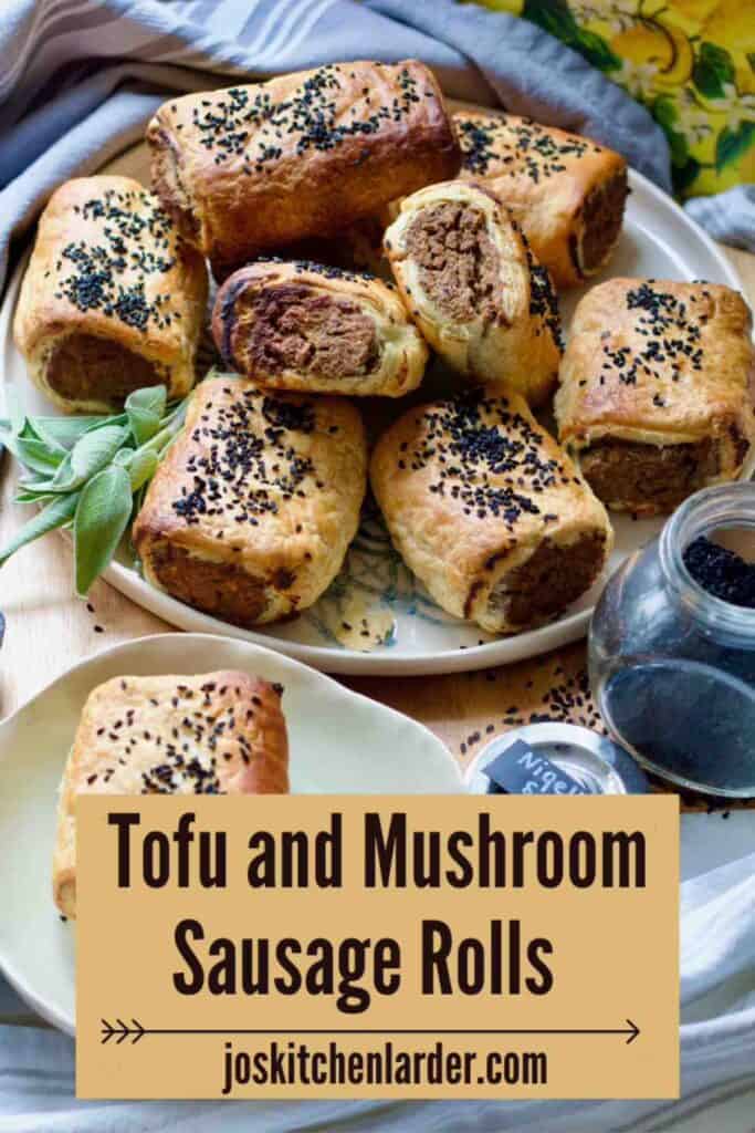 Sausage rolls piled up on a plate and one on a separate plate served with ketchup.